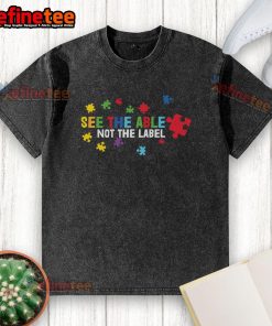 Colorful puzzle piece design on a washed t-shirt promoting autism awareness with the phrase See the Able, Not the Label.