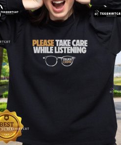 Cozy sweatshirt reading 'Please Take Care While Listening' with glasses, inspired by Nice Tenderfoot TV True Crime.