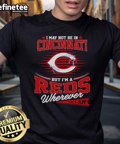 Alt Text: Official I May Not Be In Cincinnati But I Am A Reds Wherever I Am T-Shirt showcasing team pride and style.