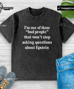 Person wearing an 'Epstein' washed t-shirt, showcasing bold text about questioning controversial topics.