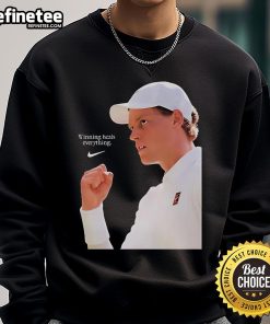 Jannik Sinner in Nike X Wimbledon 2025 sweatshirt, celebrating victory with 'Winning Heals Everything' slogan.