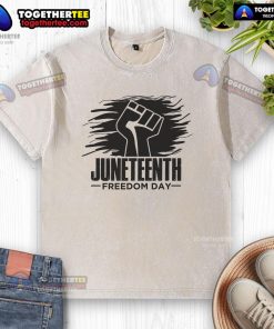 Alt Text: Official Juneteenth Freedom Day fist design on a washed t-shirt celebrating African American history and culture.
