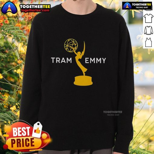 Tramell Tillman wearing an Emmy sweatshirt while posing next to a tram, showcasing his stylish look and personality.