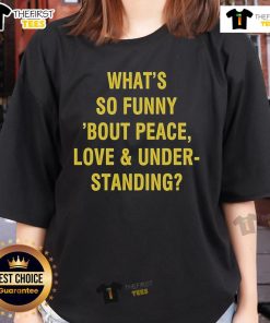 Official 'What's So Funny 'Bout Peace, Love, and Understanding' Ladies Tee showcasing a stylish design for fans.
