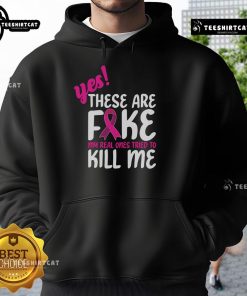 Breast Cancer Awareness hoodie with 'Yes, these are fake. My real one tried to kill me' slogan.