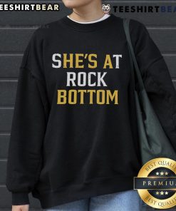 Premium 'She's At Rock Bottom, He's A Bottom' sweatshirt featuring bold text design for trendy casual wear.