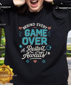 Cozy sweatshirt featuring 'Pretty Behind Every Game Over, A Restart Awaits' design, perfect for gamers and casual wear.