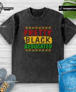Pretty black educated washed t-shirt displayed on a wooden background, showcasing its stylish design and texture.