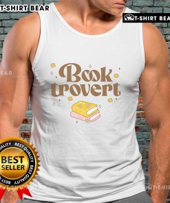 Funny book lover wearing a 'Pretty Booktrovert' tank top while reading a book in a cozy setting.