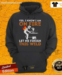 Metal worker in a 'Pretty Yes I Know I Am On Fire' hoodie, focused on welding with sparks flying, showcasing welding skills.