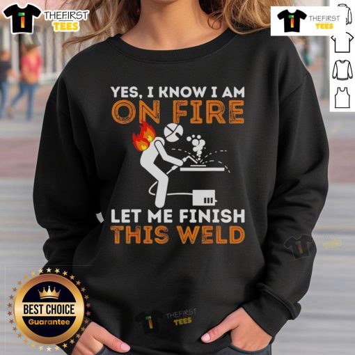 Metal worker wearing 'Pretty Yes I Know I Am On Fire' sweatshirt while welding, showcasing craftsmanship and style.