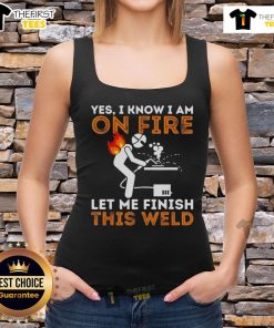Metal worker in a tank top confidently welding, showcasing skill and style with a fiery backdrop. Welders at work.