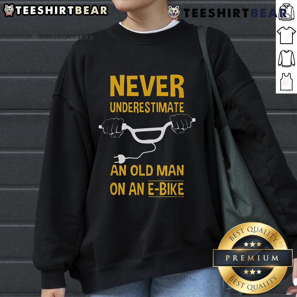 Top Never Underestimate An Old Man On An E Bike Sweatshirt Alt Text: Top Never Underestimate An Old Man On An E-Bike Sweatshirt featuring a vintage design and comfortable fit.