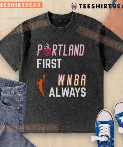 Top Portland First WNBA Always Washed T-Shirt displayed on a wooden background, highlighting its vibrant design and fabric.