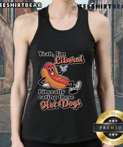 Person wearing a 'Top Yeah I'm Liberal' tank top while enjoying hot dogs at a summer barbecue.