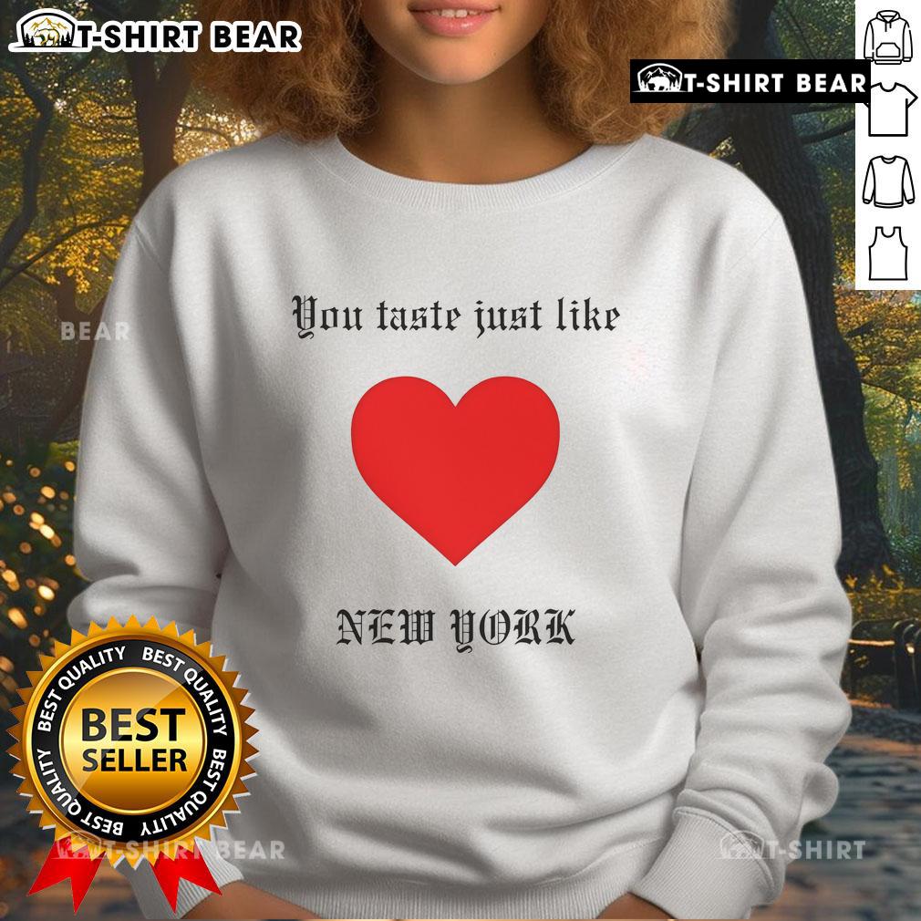 Top You Taste Just Like New York Sweatshirt Cozy 'Top You Taste Just Like New York' sweatshirt displayed on a wooden table, perfect for casual city vibes.