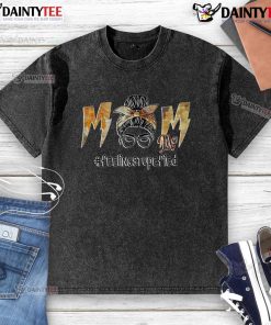 Awesome mom life: a woman with a messy bun, wearing a washed t-shirt, looking stupefied in a cozy home setting.