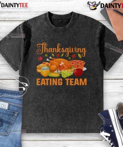 Awesome Thanksgiving eating team enjoying a turkey day feast in food lovers washed t-shirts, smiling and sharing dishes.