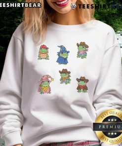 Alt Text: Cute frogs dressed as cowboys and witches on a sweatshirt, perfect for playful fashion lovers.
