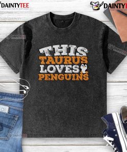Cute Taurus loves penguins graphic on a washed t-shirt, perfect for astrology and animal lovers.