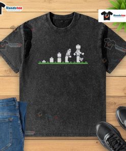 Alt Text: Funny Lego human evolution graphic on a washed t-shirt, showcasing playful Lego characters in evolution stages.