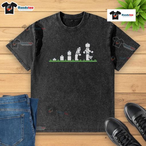 Alt Text: Funny Lego human evolution graphic on a washed t-shirt, showcasing playful Lego characters in evolution stages.