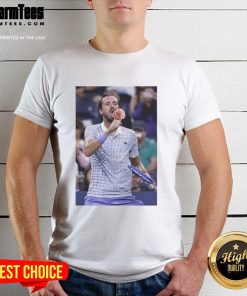 Funny Medvedev licks ice cream on the field wearing a US Open T-shirt, capturing a lighthearted tennis moment.