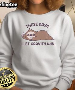 Funny sloth sweatshirt featuring the phrase 'These days I let gravity win' for relaxed, humorous fashion lovers.