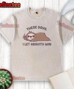 Funny sloth graphic on a washed t-shirt, captioned These days I let gravity win, ideal for casual wear and humor lovers.