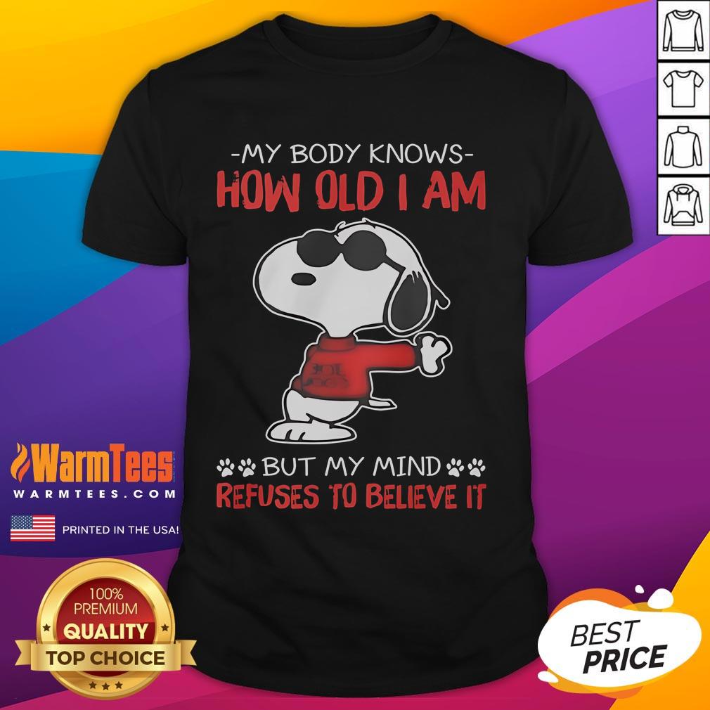 Funny Snoopy My Body Knows How Old I Am But My Mind Refuses To Believe It T-Shirt Alt Text: Funny Snoopy t-shirt featuring the phrase My Body Knows How Old I Am But My Mind Refuses To Believe It.