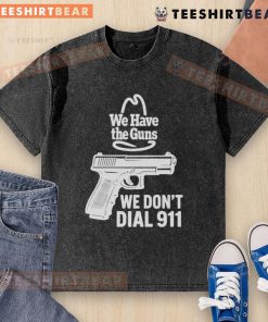 Funny 'We Have The Guns, We Don't Dial 911' washed t-shirt displayed on a wooden background, perfect for casual wear.