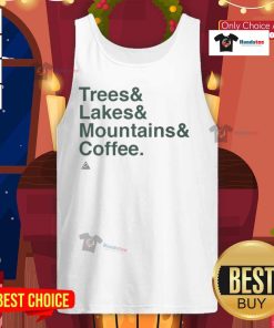 Person wearing a 'Good Trees, Lakes, Mountains, and Coffee' tank top, surrounded by nature with trees and mountains in the background.
