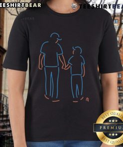 Father and son wearing Happy New York Mets neon ladies tee, celebrating team spirit at a baseball game.