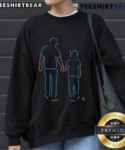 Father and son wearing Happy New York Mets neon sweatshirts, showcasing team spirit and family bonding at a game.