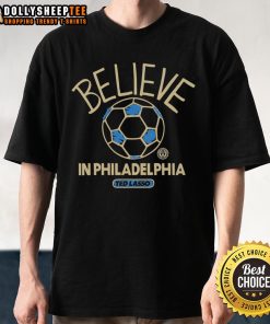 Alt Text: Happy Ted Lasso wearing a Believe In Philadelphia T-shirt, showcasing positivity and team spirit in a vibrant design.