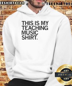 Happy teacher wearing a 'This Is My Teaching Music' hoodie, showcasing passion for music education in a vibrant classroom.