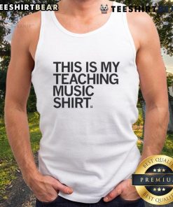 Alt Text: Happy music teacher wearing 'This Is My Teaching Music' tank top, showcasing passion for music education in a vibrant classroom.
