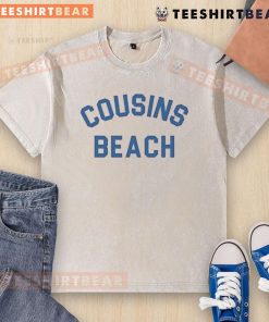 Nice cousins wearing beach-washed t-shirts, enjoying a sunny day by the ocean, showcasing vibrant summer style.