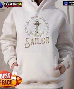 Cozy 'Nice Smooth Sea Never Made A Skilled Sailor' hoodie displayed against a serene ocean backdrop, perfect for sailing enthusiasts.