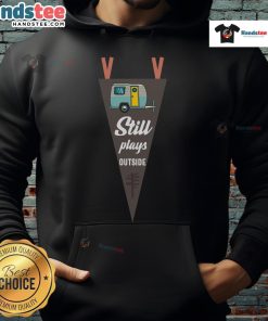 Nice still plays outside RV camper wearing a cozy camping hoodie, enjoying nature and outdoor adventures.
