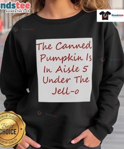 Canned pumpkin on shelf in aisle 5, next to Jell-O and a colorful sweatshirt, showcasing seasonal grocery items.