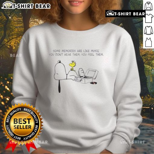 Premium Snoopy sweatshirt featuring the quote 'Some memories are like music, you don't hear them, you feel them.'