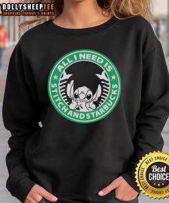 Cozy 'All I Need Is Stitch And Starbucks' sweatshirt displayed on a wooden table with a coffee cup and sewing supplies.