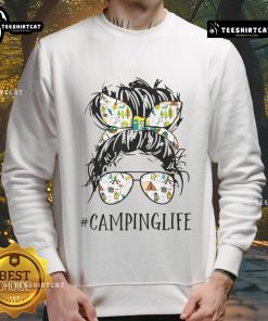 Mom in a messy bun wearing a 'Pretty Camping Life' sweatshirt, enjoying a cozy camping experience in nature.