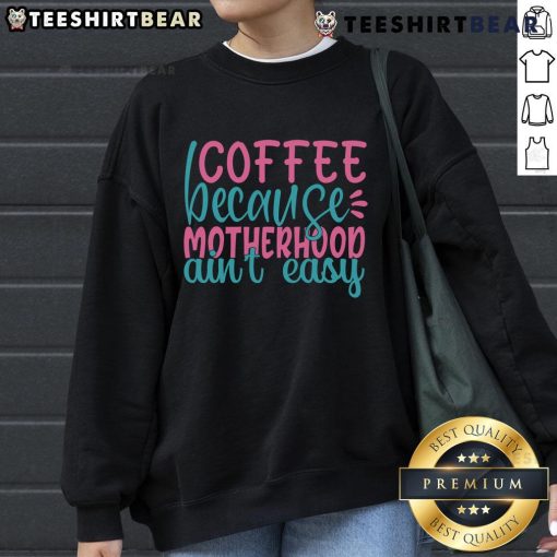 Cozy 'Pretty Coffee Because Motherhood Ain't Easy' sweatshirt displayed with a cup of coffee, perfect for moms seeking comfort.