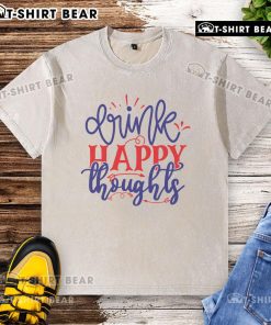 Pretty drink in a glass beside a happy thoughts washed t-shirt on a sunny day, showcasing vibrant colors and joyful vibes.