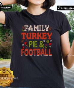 Pretty family enjoying turkey pie while watching football in a cozy living room, showcasing the 'Turkey Pie and Football' tee.