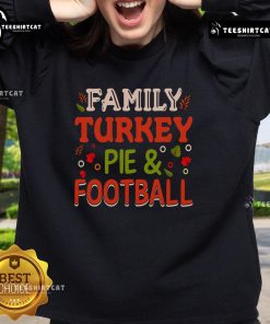 Pretty family wearing turkey pie and football sweatshirts, celebrating Thanksgiving together in a cozy living room.