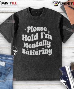 Pretty Please Hold I'm Mentally Buffering washed t-shirt displayed on a wooden background, showcasing its casual style.