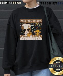 Cozy Snoopy and Woodstock sweatshirt featuring 'Music Heals The Soul' design, perfect for fans of Peanuts and music lovers.